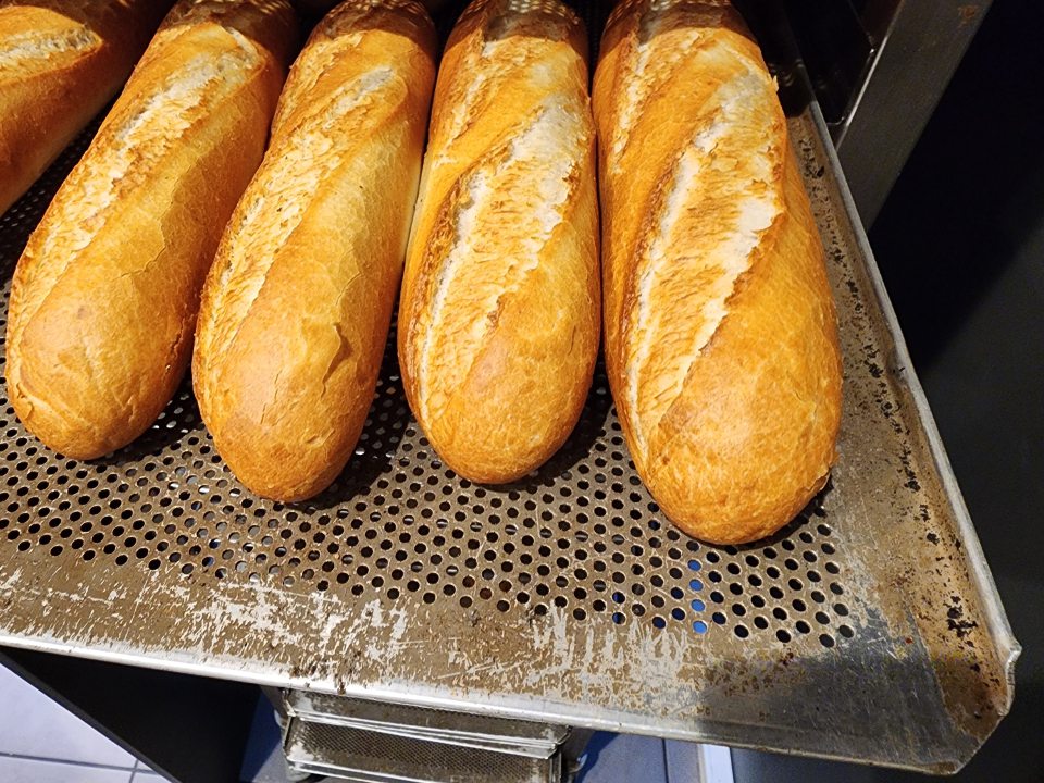 Vypečené pečivo uložené priamo (bez papiera) na znečistených plechoch.