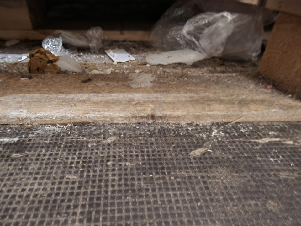 Znečistená podlaha v mraziacom zariadení, nahromadená nečistota pod paletami.