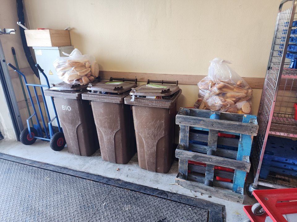 Znečistená podlaha na príjmovej rampe, skladované preplnené nádoby s odpadom.