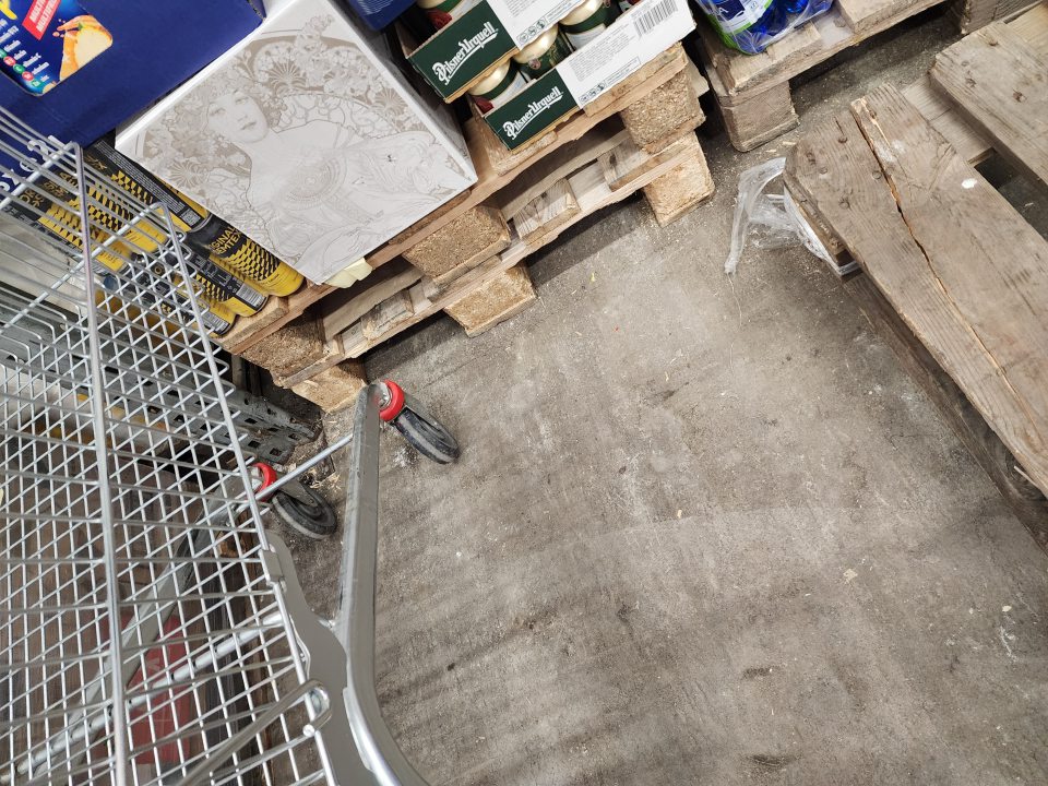 Podlahy v sklade neudržiavané, znečistené úlomkami paliet, obalov a prachom.