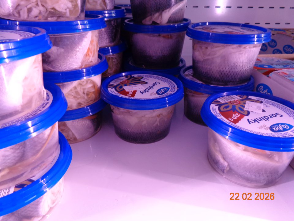 Polica znečistená vytečeným a kyslo zapáchajúcim vodnatým obsahom  v chladiacej vitrínovej skrini slúžiacej na uchovávanie  rybacích výrobkov na predajnej ploche.