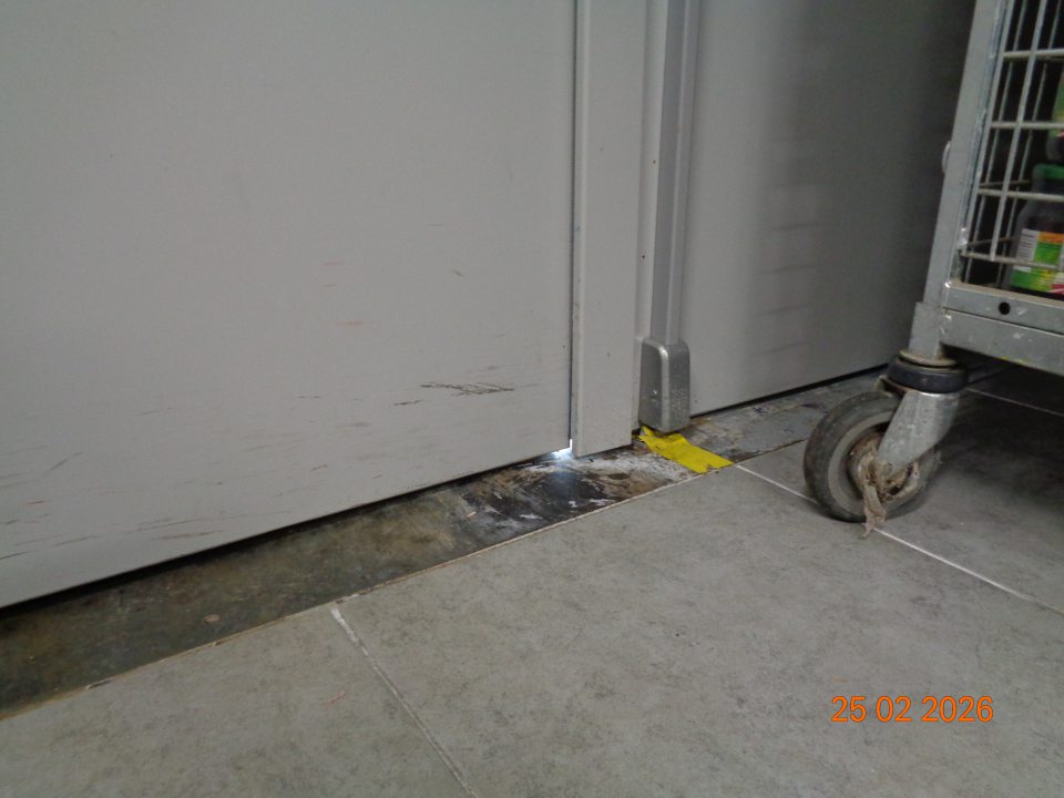 Nedostatočne priliehajúce príjmové dvere v skladovacej časti prevádzky  – štrbina v spodnej časti  v strede medzi krídlami dverí. 