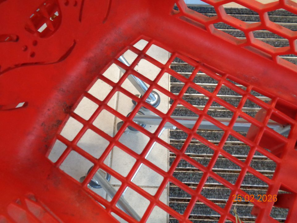 Detský umelohmotný nákupný vozík znečistený usadeným prachom a nečistotami.