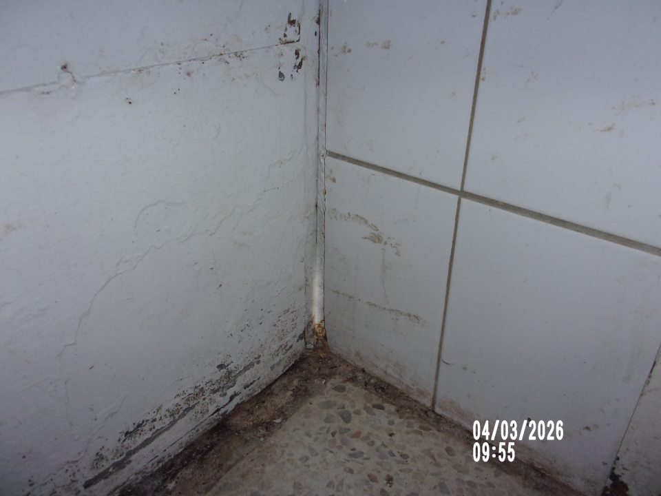 Nedostatočne priliehajúce príjmové dvere v rohu v spodnej časti v sklade surovín.