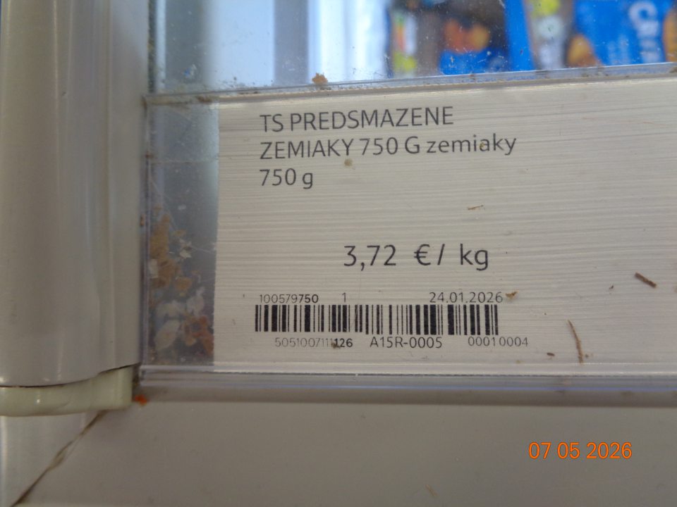 Nečistoty a špina pod plastovými lištami na cenovky na mraziacom boxe určenom na uchovávanie hlbokozmrazených polotovarov.