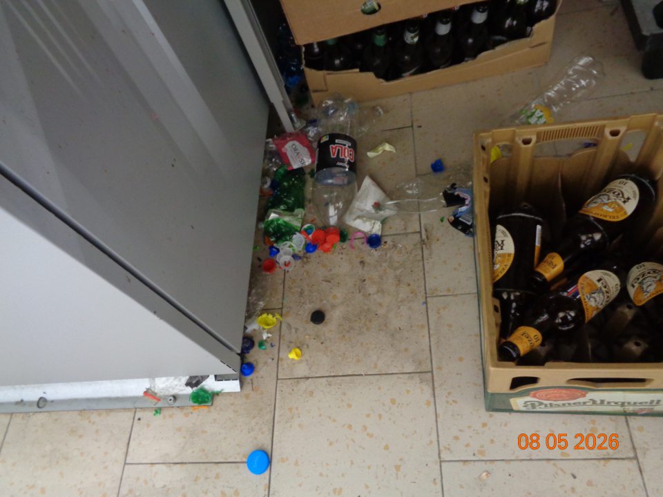 Nečistoty, špina, plastové vrchnáky od fliaš a plastové fľaše na podlahe v priestore fľaškomatu „TOMRA“ v manipulačnom priestore prevádzkarne. 