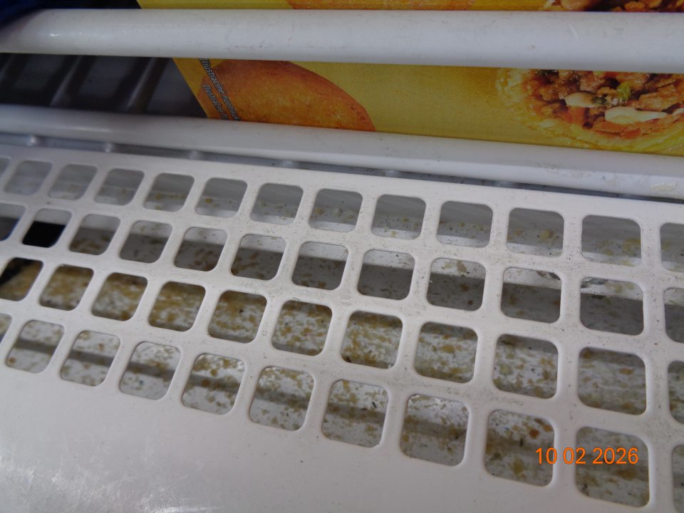 Mraziarenské vitríny na predajnej ploche na uchovávanie hlbokozmrazenej pizze a polotovarov v priestoroch pod mriežkami znečistené nečistotami a prachom.