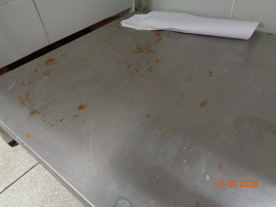 Hrdza na úložnej ploche regálu v chladiacom boxe na uchovávanie lahôdok v skladovacej časti prevádzky.