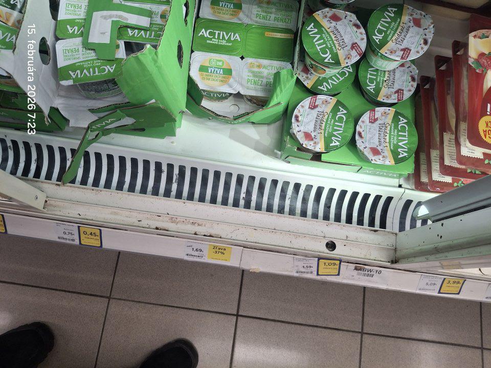 Znečistené chladiace zariadenie na mliečne výrobky - vodiaca lišta na posuvné dvierka znečistené prachom.