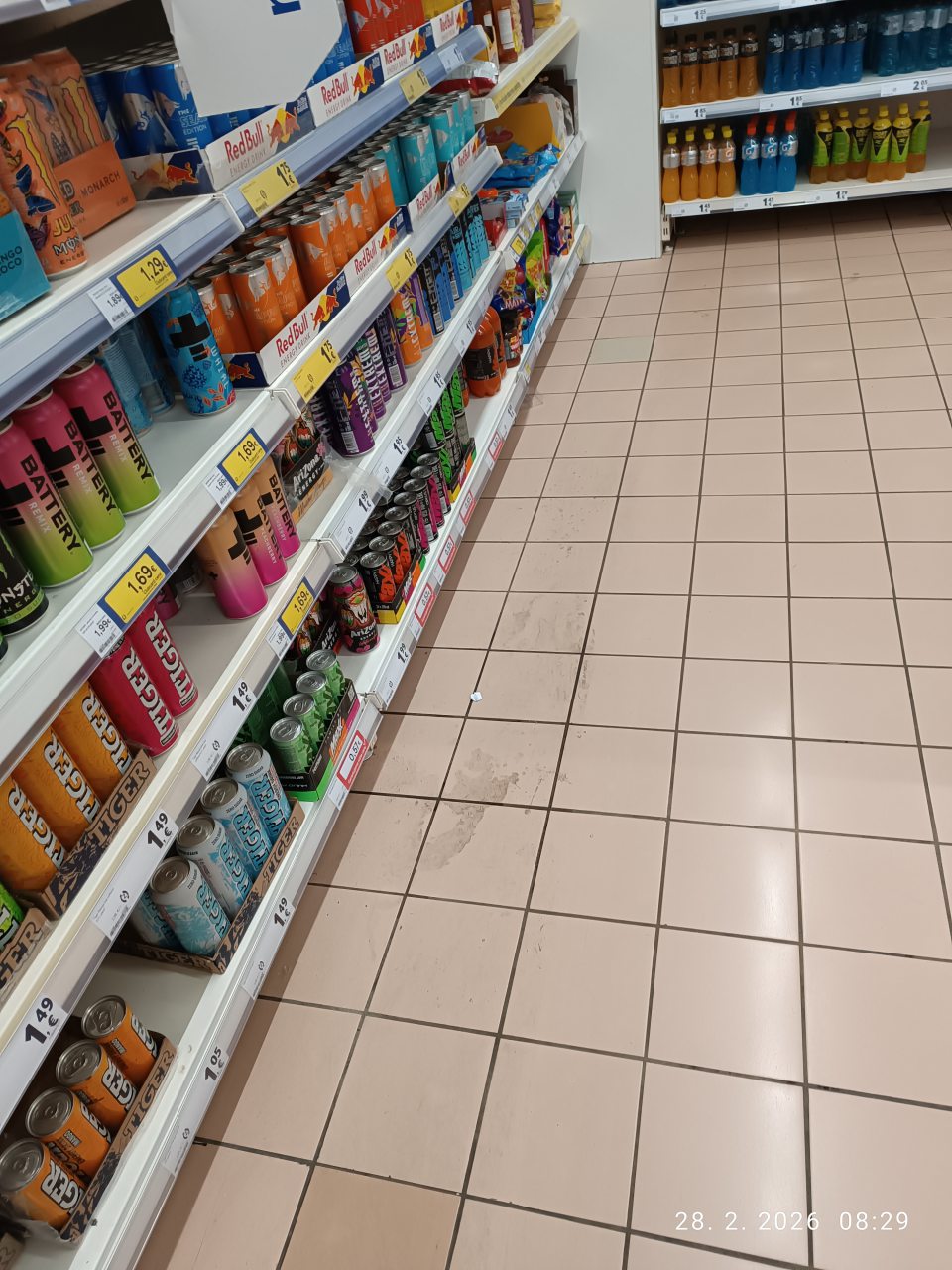 nevyhovujúci stav podlahy na predajnej ploche pri regáli s nápojmi- podlaha znečistená po rozliatí obsahu nápojov