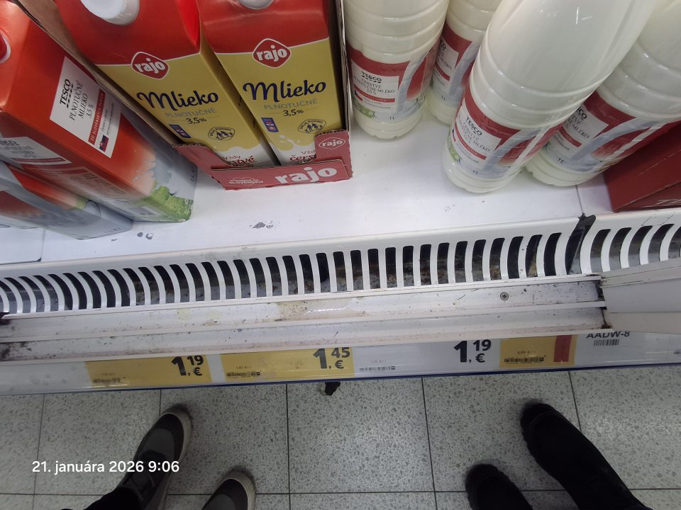 Znečistená vodiaca lišta na predajnej ploche pri predaji mlieka.