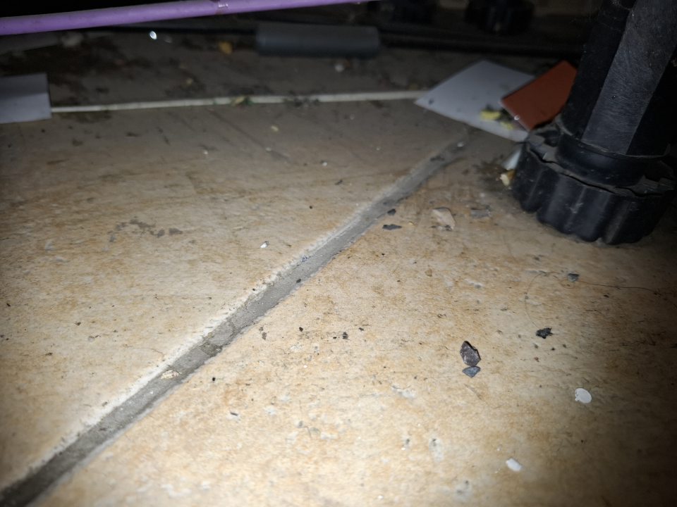 Znečistená podlaha pod regálmi na predajni. 