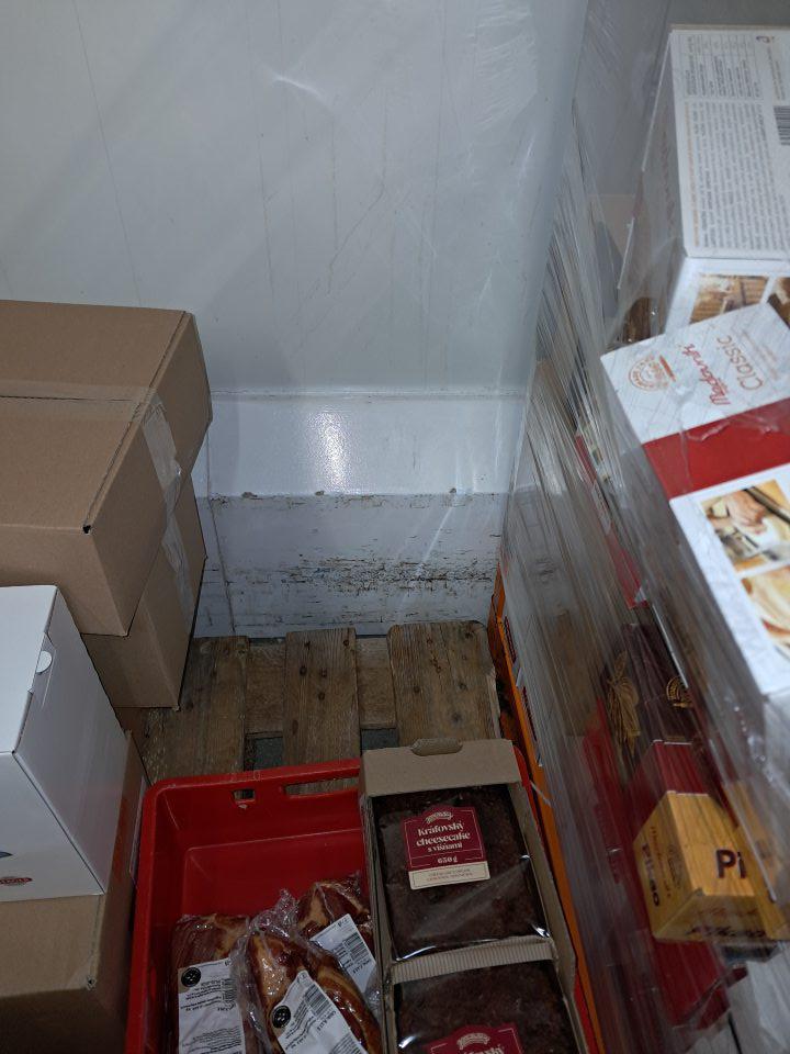 Poškodený povrch zábran na stenách na viacerých miestach v chladiacom boxe.