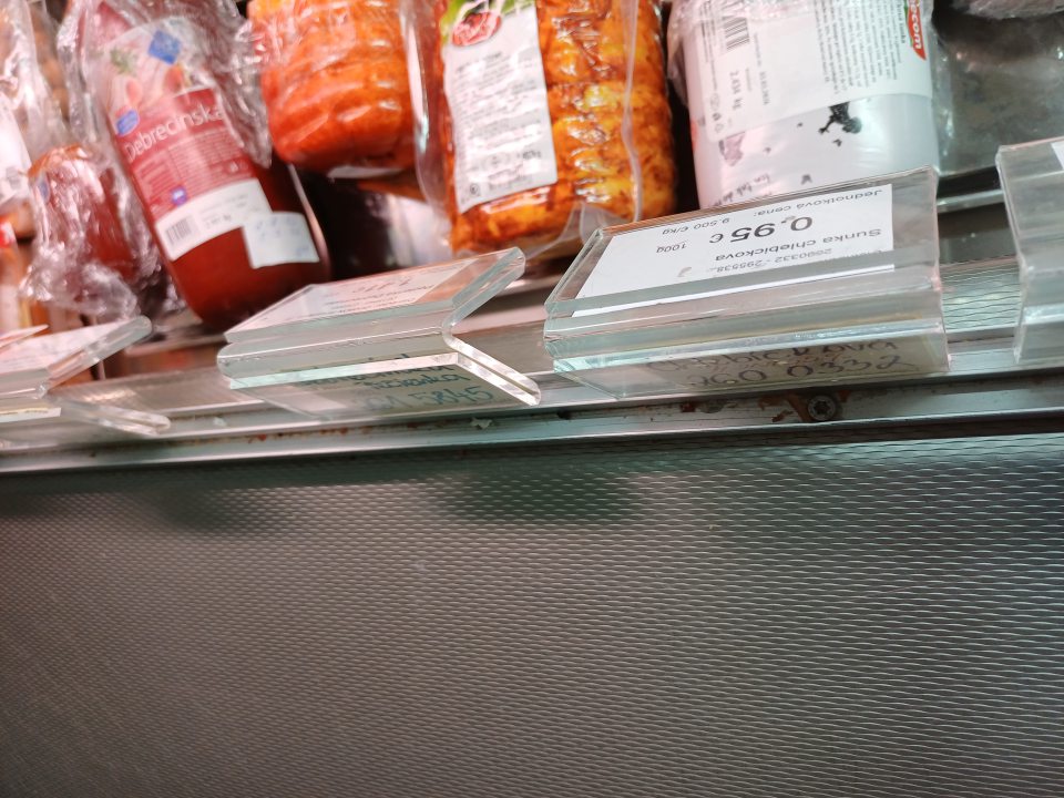 Znečistená chladiaca vitrína na mäsové výrobky v drážkach posuvných dvierok.