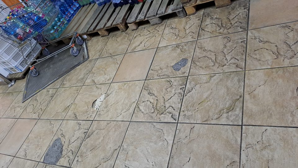 1. Poškodená keramická dlažba v suchom sklade potravín výmole na viacerých miestach.