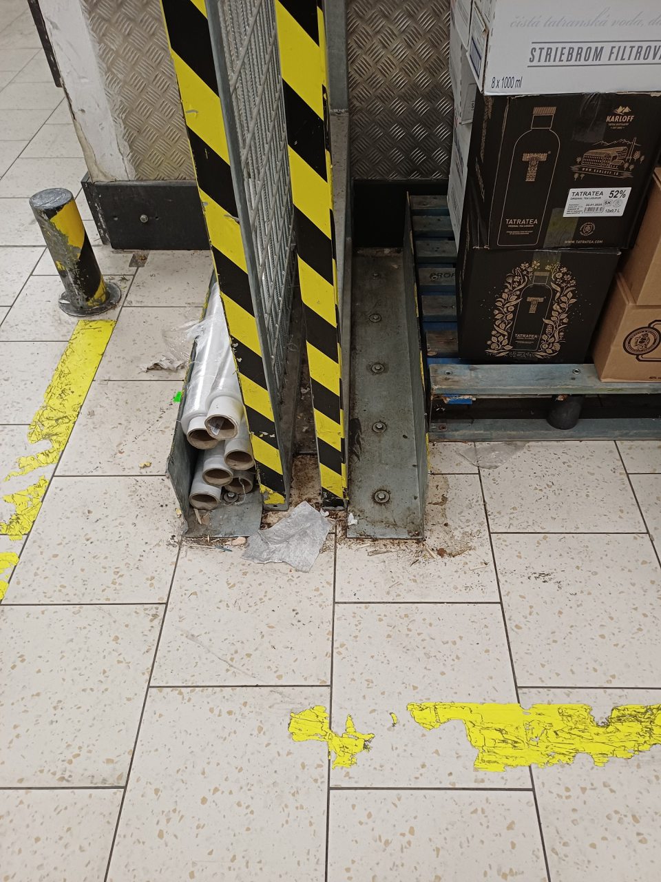 V zázemí prevádzky kde sú skladované potraviny je podlaha na viacerých miestach znečistená hrubou nečistotou, prachom, zvyškami obalového materiálu, kúskami dreva.